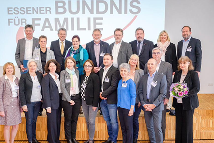 Gruppenfoto, dahinter eine Projektion des Schriftzuges "Essener Bündnis für Familie"